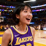 一位短发女性球迷的头像照片，她穿着湖人队球衣，背景为NBA比赛现场，表情兴奋。